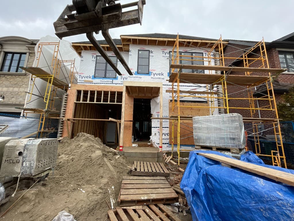 Custom home under construction with framing and scaffolding in Toronto