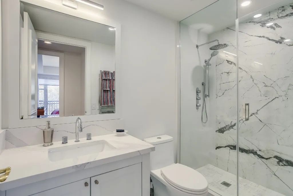 Condo bathroom with marble shower and chrome fixtures in North Toronto, Toronto
